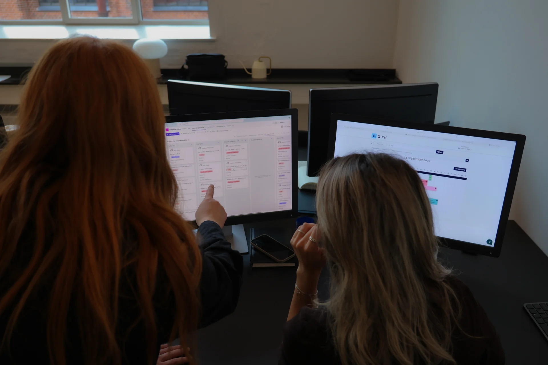 To medarbejdere hos Blue Forest gennemgår digitalt indhold ved computeren.
