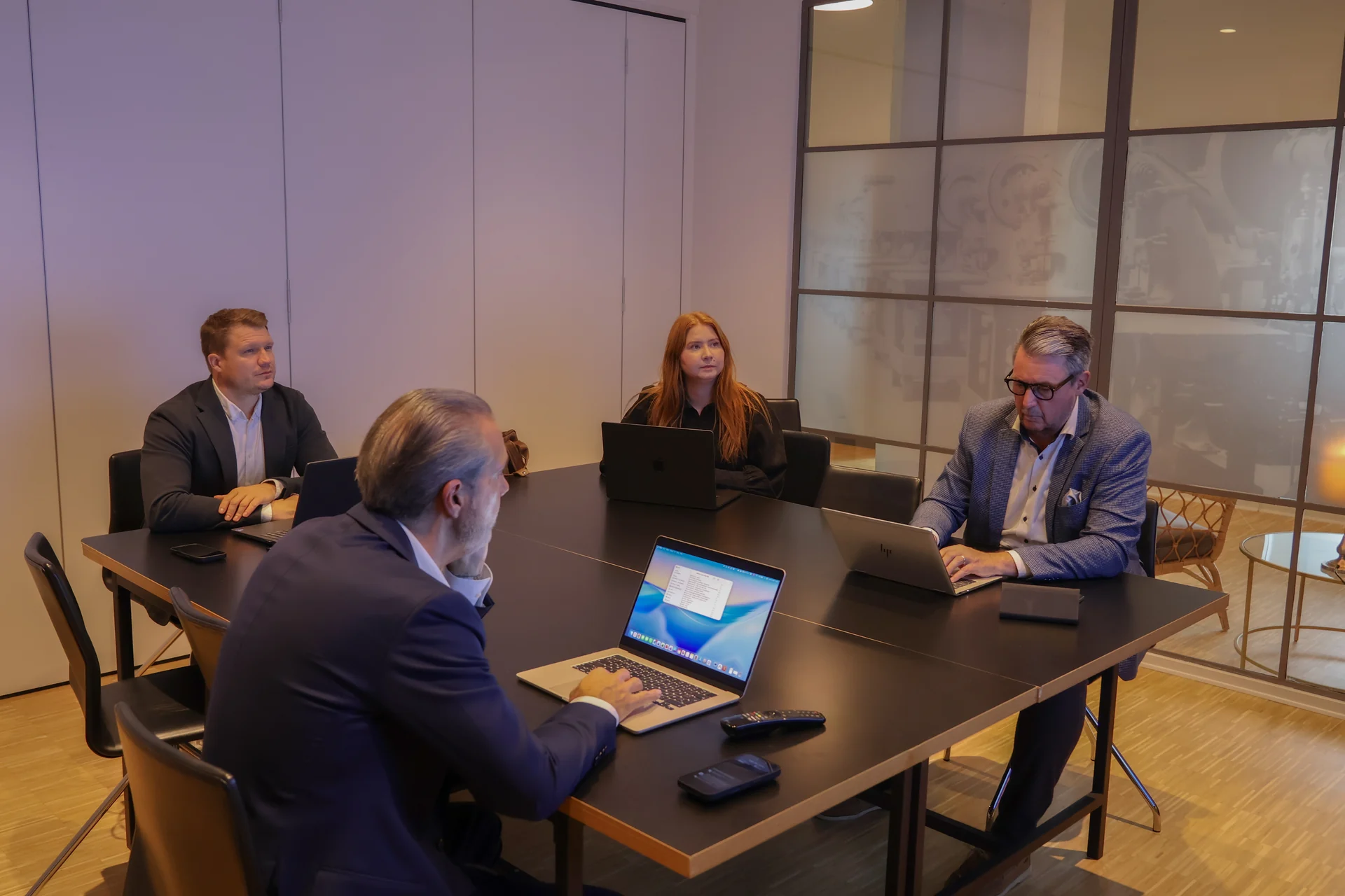 Blue Forests team i dialog omkring mødebordet med bærbare computere.